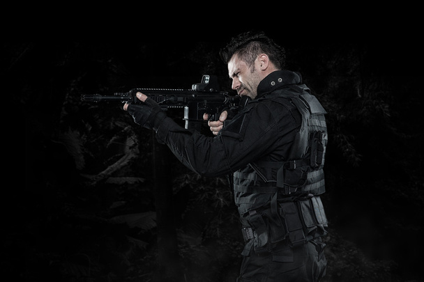 Spec ops police officer SWAT in black uniform studio - Fotografie, Obrázek