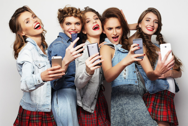 group of young women looking at their smartphones - Foto, afbeelding