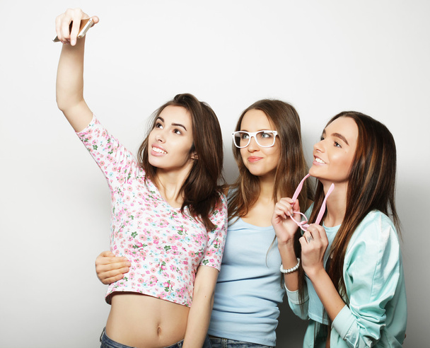 three happy teenage girls with smartphone taking selfie - Фото, изображение
