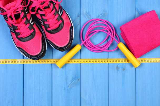 Pair of pink sport shoes and accessories for fitness on blue boards, copy space for text - Fotografie, Obrázek