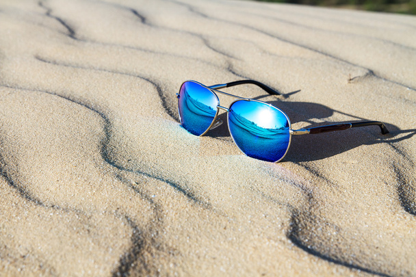 Γυαλιά ηλίου πάνω στην άμμο στην έρημο. - Φωτογραφία, εικόνα