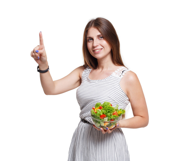 La donna sorridente tiene l'insalata vegetale fresca e tocca lo schermo immaginario
 - Foto, immagini