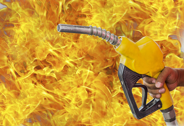 Holding a fuel nozzle against white flame background. - Photo, Image