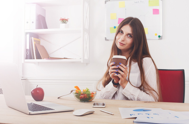 Woman has healthy business lunch in modern office interior - Photo, Image