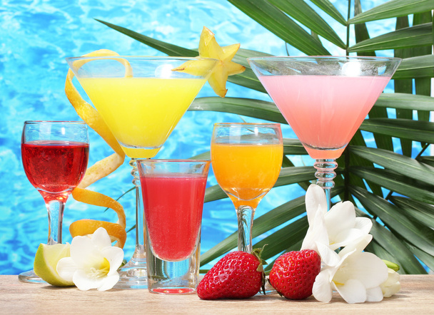 Exotic cocktails and flowers on table on blue sea background - Valokuva, kuva