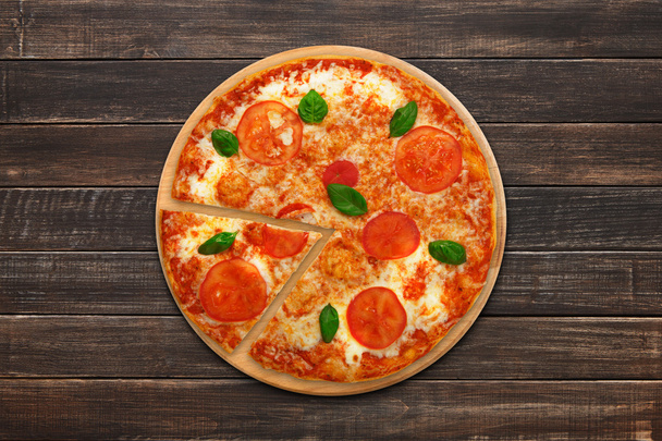 Deliciosa pizza vegetariana italiana Margherita vista superior em madeira
 - Foto, Imagem