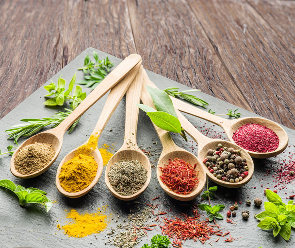 Assortment of colorful spices in the wooden spoons. - Фото, изображение