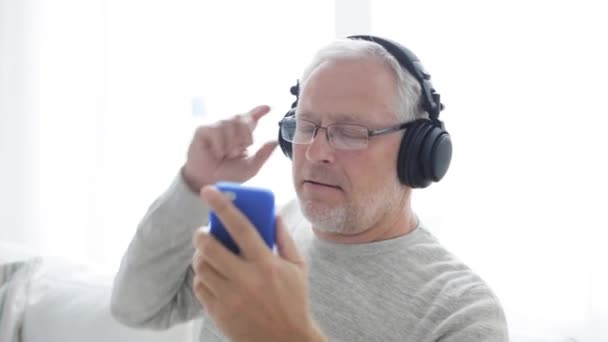 happy senior man with smartphone and headphones 16 - Video, Çekim
