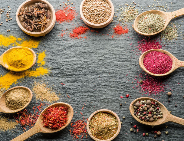 Assortment of colorful spices in the wooden spoons. - Photo, image