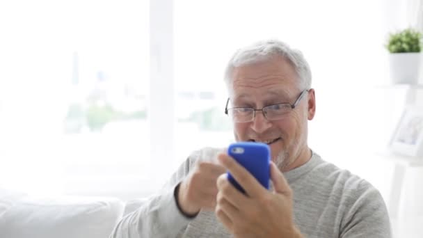 senior man having video call on smartphone at home 18 - Záběry, video