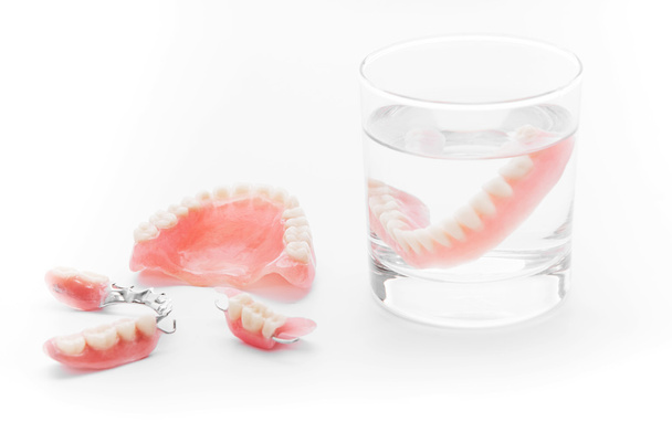 Set van gebit in glas water op witte achtergrond - Foto, afbeelding