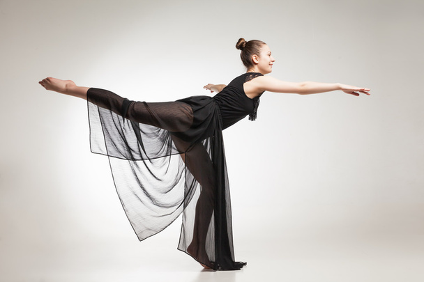 Young ballet dancer wearing black transparent dress dancing - Foto, Imagem
