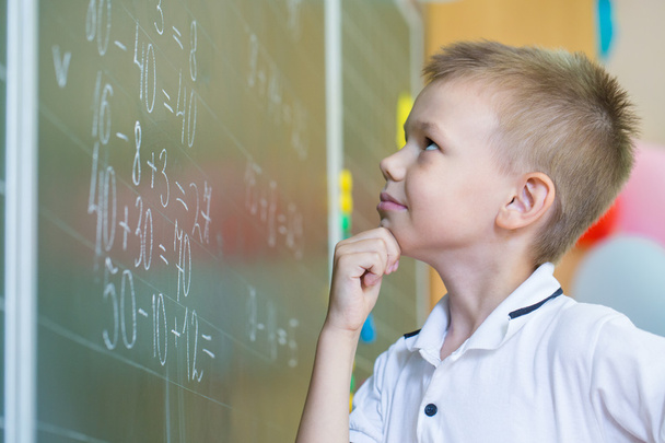 Schoolboy standing near blackboard  - Φωτογραφία, εικόνα