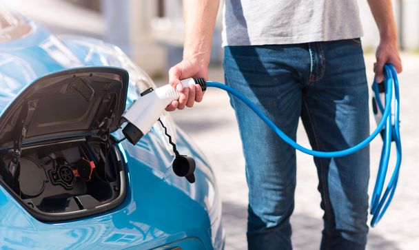 Man turning on charging of car - Фото, зображення