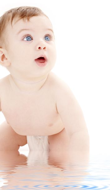 Portrait of crawling baby boy looking up - 写真・画像