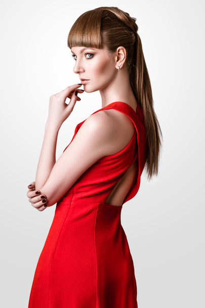 beautiful woman model posing in simple elegant red dress in the studio on white background - Fotoğraf, Görsel