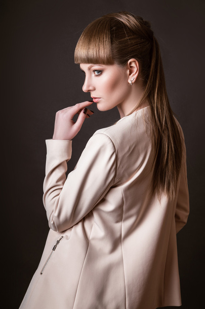 beautiful woman model posing in simple elegant in a light suit in the studio on black background - Fotografie, Obrázek