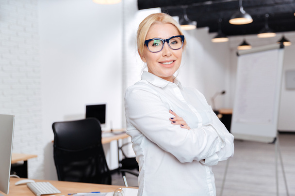 Mature business woman standing with arms folded in office - Fotografie, Obrázek