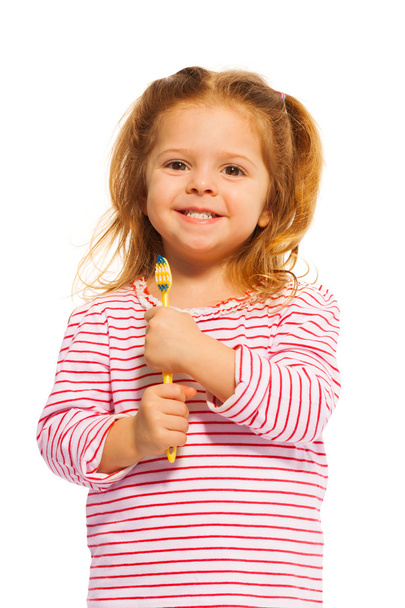 menina segurando escova de dentes amarela
 - Foto, Imagem