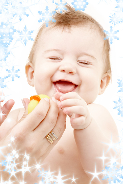 Laughing baby boy in mother hands with rubber duck - Фото, изображение