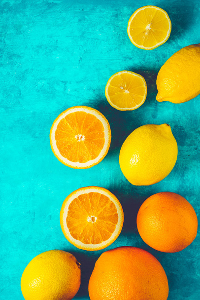 Lemons and oranges on the cyan background vertical - Foto, afbeelding