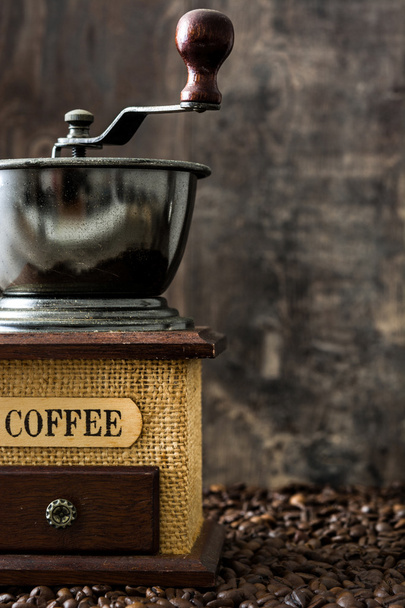 Macinino da caffè e chicchi di caffè su sfondo rustico in legno
 - Foto, immagini