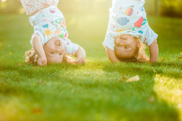 The two little baby girls hanging upside down - Zdjęcie, obraz