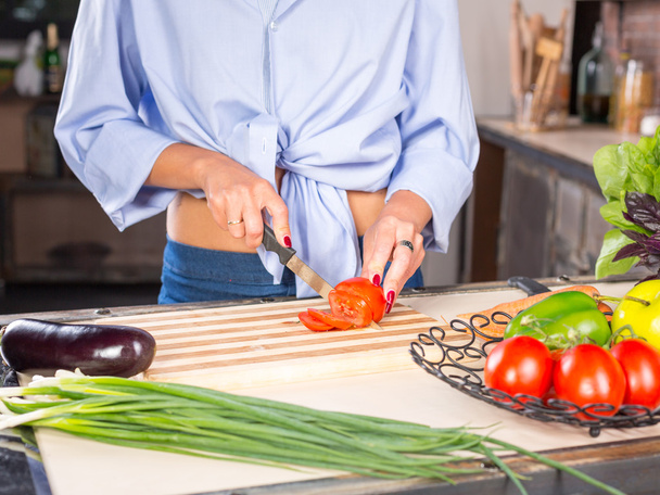woman slicing tomato on kitchen - Valokuva, kuva