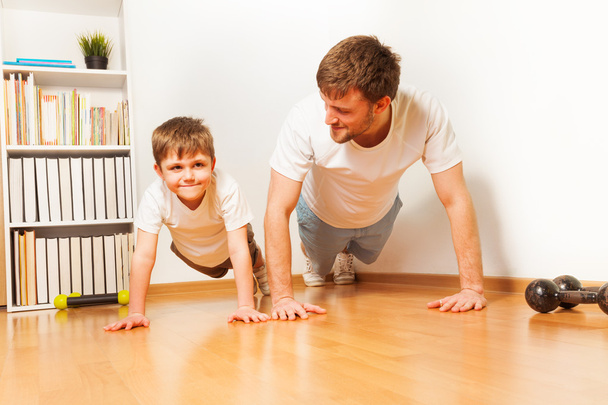Father teaching his  son doing push-ups - Фото, изображение
