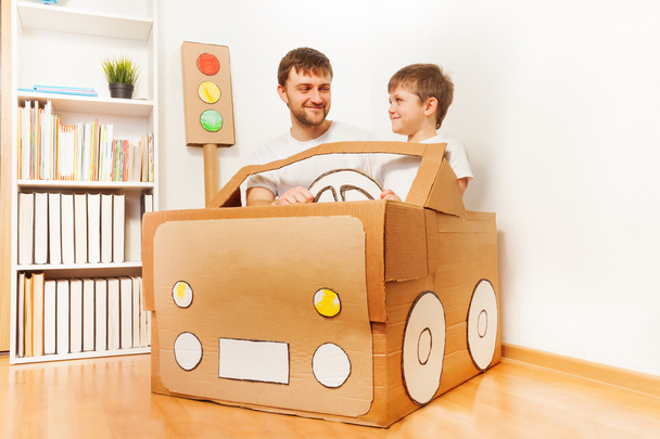 Father and son driving  cardboard car  - Photo, image