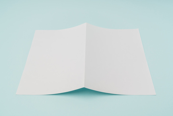 Bifold white template paper on blue background . - Foto, afbeelding