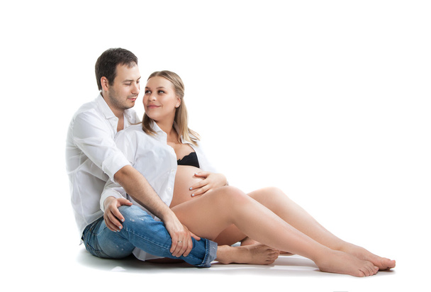 Beautiful young couple expecting baby. A happy family. Isolation on a white background. Pregnancy, childbirth. - Foto, afbeelding