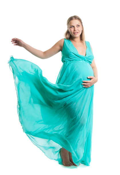 Young pretty pregnant woman. A woman waiting for a child. The joy of motherhood. Light air summer dress, white background. - Fotó, kép