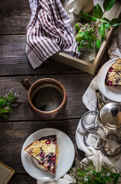 Cup of tea and slice of blueberry pie on dark wooden background. - Fotó, kép