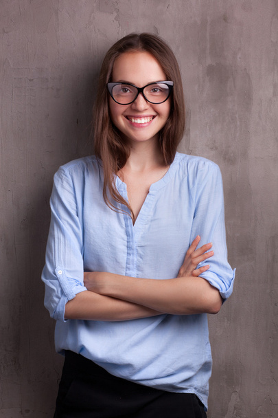 portrait of beautiful happy young woman with glasses near grey background wall - Zdjęcie, obraz
