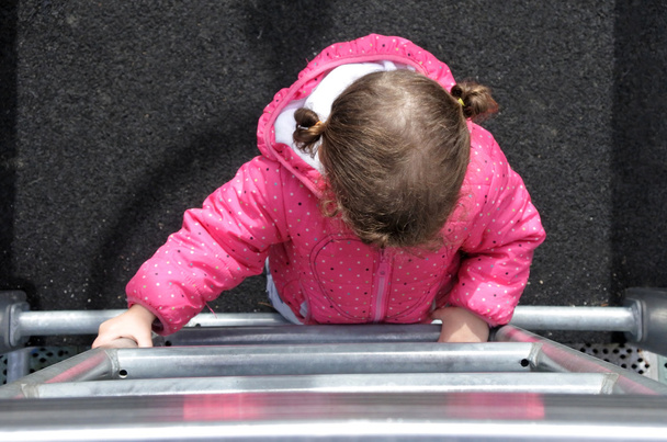 Плоский вигляд маленької дівчинки піднімається на драбину
  - Фото, зображення