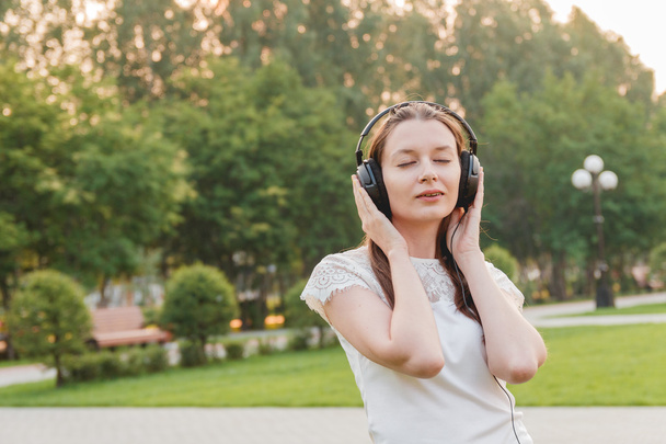Young Caucasian Brunette Woman with Headphones Outdoors - Foto, Imagem