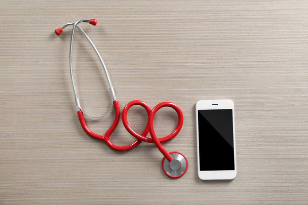Red stethoscope with cellphone  - Zdjęcie, obraz