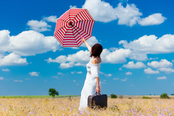 молодая женщина с чемоданом и зонтиком
 - Фото, изображение