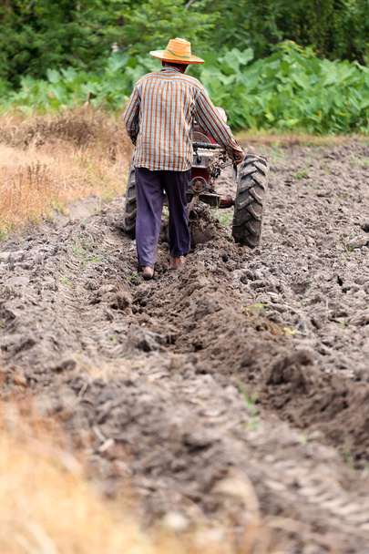 Mezőgazdasági termelők dolgozik ellenőrzési pushcart a talaj-növény helyrehoz. - Fotó, kép