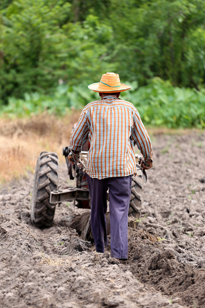 Les agriculteurs travaillent le chariot de commande pour reconditionner la culture du sol
. - Photo, image