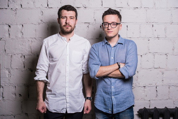 Two young men startupers over grey brick wall loft interior design - Fotoğraf, Görsel
