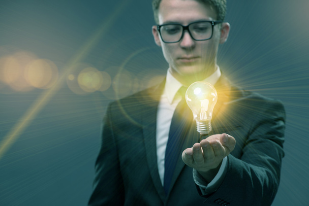 Young businessman with light bulb in idea concept - Photo, Image