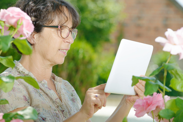 Portret van een volwassen vrouw met een tablet - Foto, afbeelding