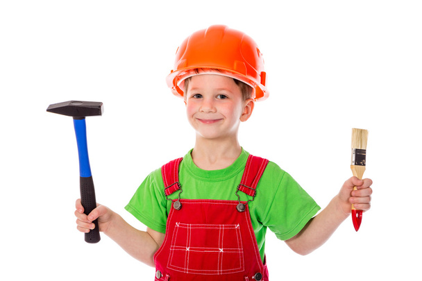 Little builder in helmet with paintbrush and hummer - Fotografie, Obrázek
