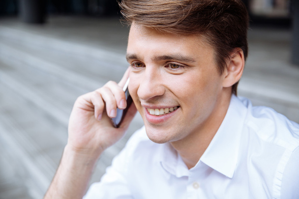 Cheerful young businessman talking on mobile phone - Foto, Imagen