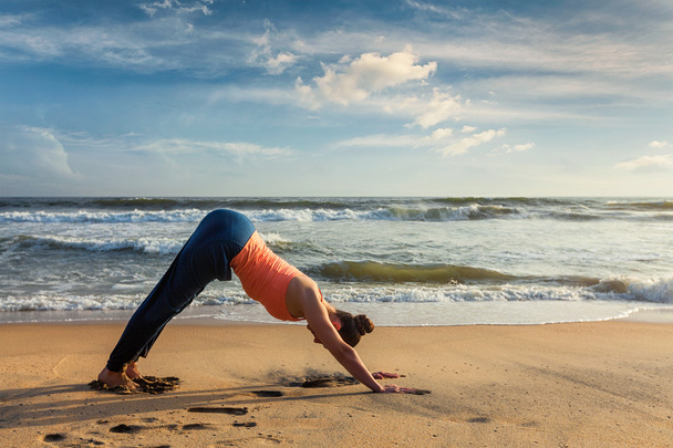 Mujer haciendo yoga Surya Namaskar al aire libre en la playa tropical
 - Foto, imagen