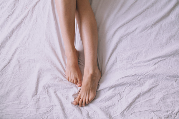 ベッドで人間の足 - 写真・画像