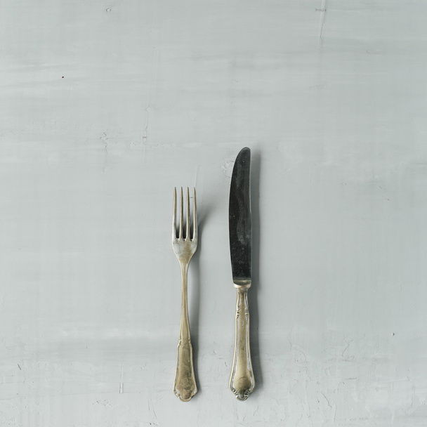 gouden vork en mes op grijs - Foto, afbeelding