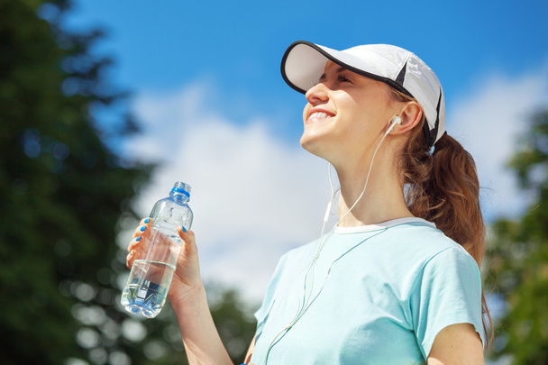 Portrait of happy fitness woman drinking water after workout. - Foto, Imagen